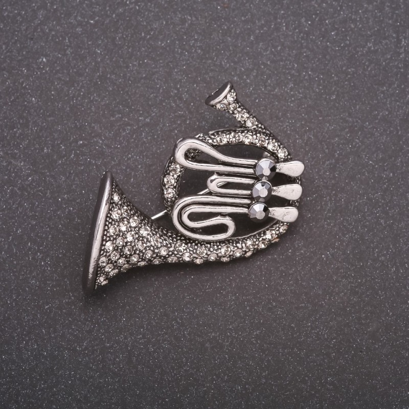 Broche en forma de trompeta con strass, metal gris