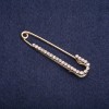 Broche-pasador con strass blancos, 57 × 13 mm, metal dorado